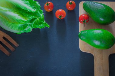 Bir kesme tahtası ahşap zemin üzerinde taze avokado. sağlıklı food.copy alanı