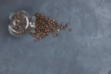 kavrulmuş kahve çekirdekleri cam kavanozdan döktü. kahve nesnesinin açısal yerleştirme.