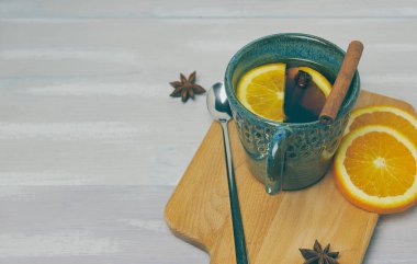 Tarçın ve turuncu bir rustik beyaz tablo ile ısınma çay seramik bir fincan. kopya alanı. Dikey görünüm ..