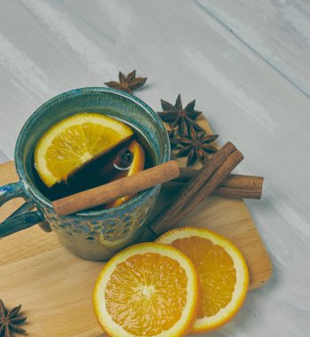 Tarçın ve turuncu bir rustik beyaz tablo ile ısınma çay seramik bir fincan. kopya alanı. Dikey görünüm ..