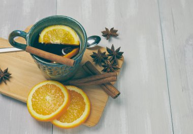 Tarçın ve turuncu bir rustik beyaz tablo ile ısınma çay seramik bir fincan. kopya alanı. Dikey görünüm ..