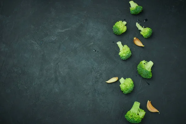 Yeşil brokoli karanlık bir arka plan üzerinde sağlıklı beslenme şekli kesimleri. Uzay kopyalayın. Yukarıdan görüntüleyin. Vejetaryen gıda.