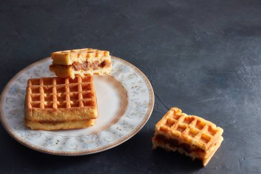 Üstten görünüm tatlı taze Viyana waffle ahşap masaya izole plaka üzerinde. kopya alanı. kahvaltıda hamur işleri.