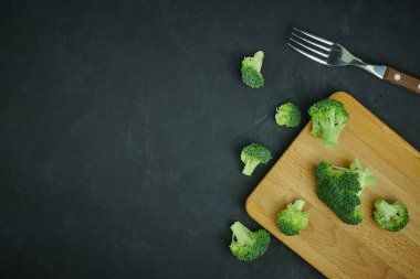 plaser yeşil brokoli kesimi küçük bir kova. Koyu arka plan üzerinde desen yeme sağlıklı. Alanı yukarıdan kopyalayın. Vejetaryen yiyecekler.