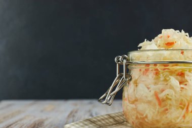 bir kavanoz içinde bir ışık, Beyaz ahşap masa, lahana bir kavanoz içinde dikey bir tür baharat kendi suyuyla havuç ve lahana turşusu. geleneksel ev yapımı, fermente çanak Rusya ve Almanya.