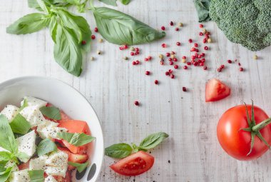 Ahşap arka plan, beyaz peynir ve fesleğen taze sebze ile Yunan salatası. Aşk için sağlıklı çiğ gıda kavramı.
