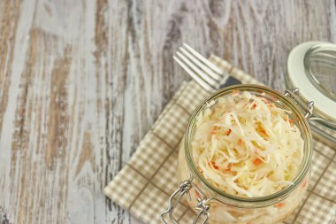 bir kavanoz içinde bir ışık, Beyaz ahşap masa, lahana bir kavanoz içinde dikey bir tür baharat kendi suyuyla havuç ve lahana turşusu. geleneksel ev yapımı, fermente çanak Rusya ve Almanya.