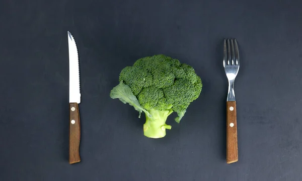 sağlıklı beslenme kavramı. yeşil, çiğ brokoli aletleri üzerinde siyah bir arka plan ile bir plaka üzerinde yalan. sağlıklı beslenme. yeşil lahana yakın çekim. HLS.
