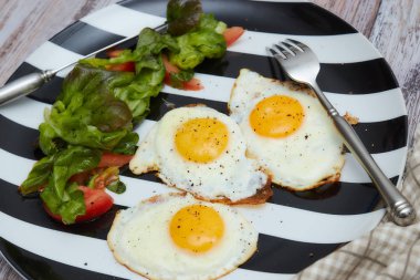 Sabah sağlıklı bir kahvaltı. kızarmış yumurta taze marul ve sebze. plaka ile eski, ışık, eski püskü bir masada. Üstten görünüm