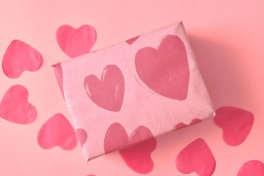 Pembe bir arka plan üzerinde kırmızı kalpler kalp ile Kraft kağıt hediye. Sevgililer günü kavramı.