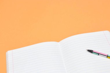 Defter, kalem ve turuncu arka plan üzerinde renkli numaraları. Çalışma için aksesuarlar. Matematik,, düz, kopya alanı