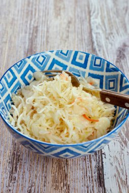 turşu lahana salatası. Geleneksel Rus meze Beyaz ahşap bir masa üzerinde bir tabak içinde havuç ile lahana turşusu. Rustik tarzı. Seçici odak ve kopya alanı