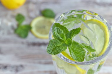 Bir bardak soğuk su buz, limon ve nane ile. Seçici odak. canlandırıcı yaz içeceği. büyük.