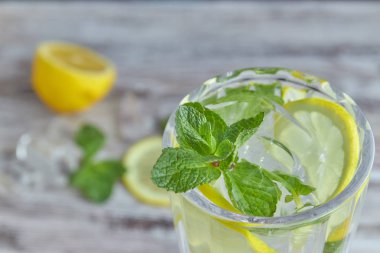 Bir bardak soğuk su buz, limon ve nane ile. Seçici odak. canlandırıcı yaz içeceği. büyük.