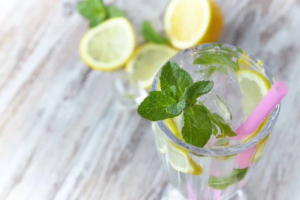 A glass of cool water with ice, lemon and mint. Selective focus. refreshing summer drink. large.