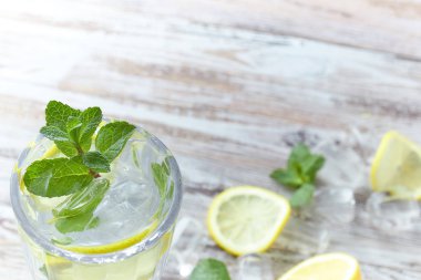 Limon ve nane ahşap bir masa üzerinde bir cam kapta su. metin için yer. serinletici yaz narenciye içki. Yaz dikey görünüm