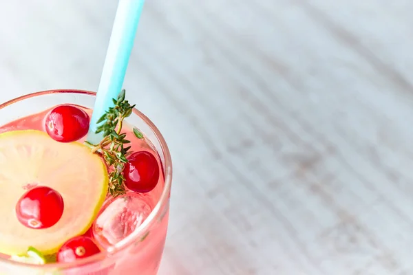 Освежающий летний напиток с ягодами и лимоном на светлом деревянном столе. Концепция летних напитков со льдом. стакан с летним коктейлем с соломой . — стоковое фото