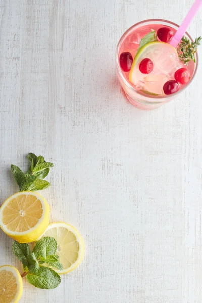 Летом пить ягодный лимонад с лимоном и льдом в стакане. Лимонад со льдом. Здоровый витаминный напиток. Принято. вид сверху . — стоковое фото