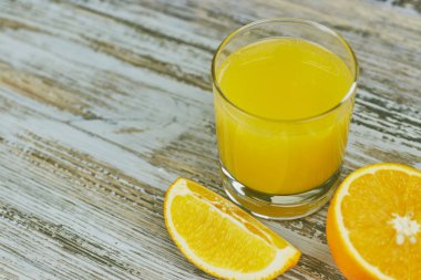 bir bardak taze portakal suyu ile ışık ahşap bir masa üzerinde taze narenciye. Yatay görünüm. narenciye suyu