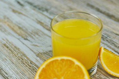 bir bardak taze portakal suyu ile ışık ahşap bir masa üzerinde taze narenciye. Yatay görünüm. narenciye suyu