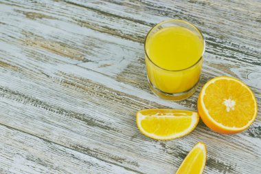 bir bardak taze portakal suyu ile ışık ahşap bir masa üzerinde taze narenciye. Yatay görünüm. narenciye suyu
