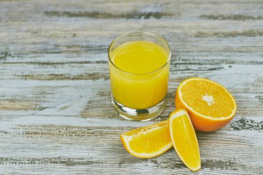 bir bardak taze portakal suyu ile ışık ahşap bir masa üzerinde taze narenciye. Yatay görünüm. narenciye suyu