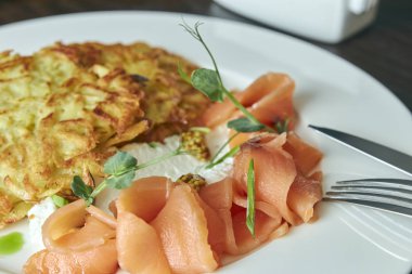 ahşap bir masa üzerine dereotu ve patates pancakes ile Marine somon çanak. taze salamura alabalık. bir tabak çanak. Rus gıda. Yatay görünüm.