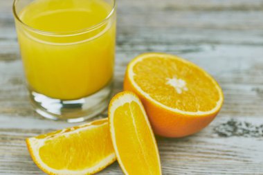 bir bardak taze portakal suyu ile ışık ahşap bir masa üzerinde taze narenciye. Yatay görünüm. narenciye suyu