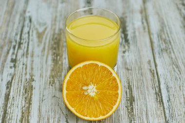 bir bardak taze portakal suyu ile ışık ahşap bir masa üzerinde taze narenciye. Yatay görünüm. narenciye suyu