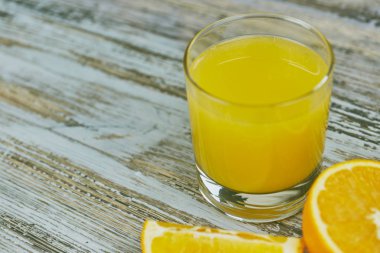 bir bardak taze portakal suyu ile ışık ahşap bir masa üzerinde taze narenciye. Yatay görünüm. narenciye suyu