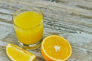 bir bardak taze portakal suyu ile ışık ahşap bir masa üzerinde taze narenciye. Yatay görünüm. narenciye suyu