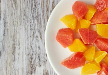 Eski püshon ahşap bir masada portakal-greyfurt narenciye salatası. kopya alanı. yaz vitamin salatası.