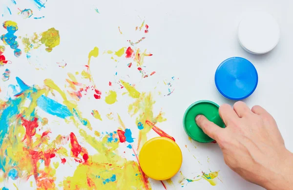 beyaz bir arka plan, parmak boyaları, el baskıları üzerinde çizim için çocuk mürekbesleri.