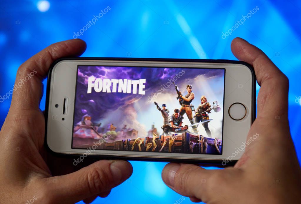 San Francisco, CA USA - April 2019: hand holding a phone with a Fortnite game logo