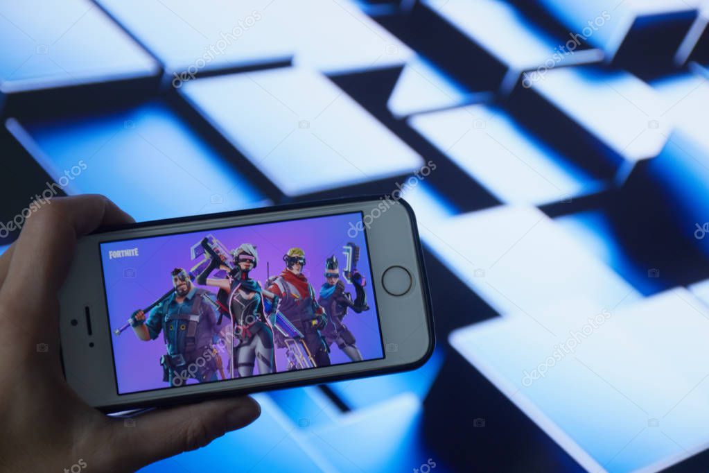 San Francisco, CA USA - April 2019: hand holding a phone with a Fortnite game logo