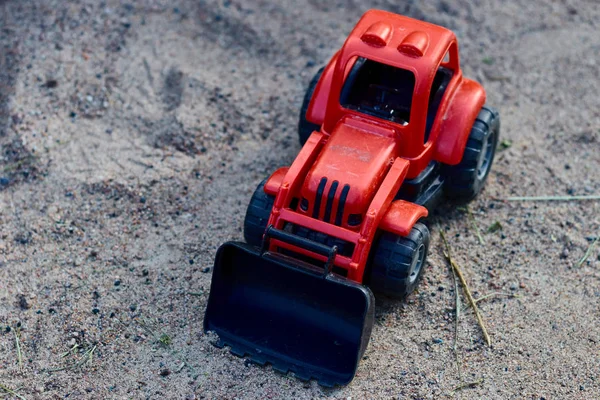 Teddyroter Traktor im Sand. Kinderspielzeug. Spielzeugkonzept für Kinder. Kopierraum. — Stockfoto