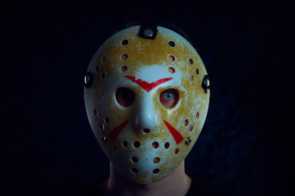 Friday 13th hockey mask of Jason Voorhees. Halloween concept. day of death. man in a jason mask on a black background.