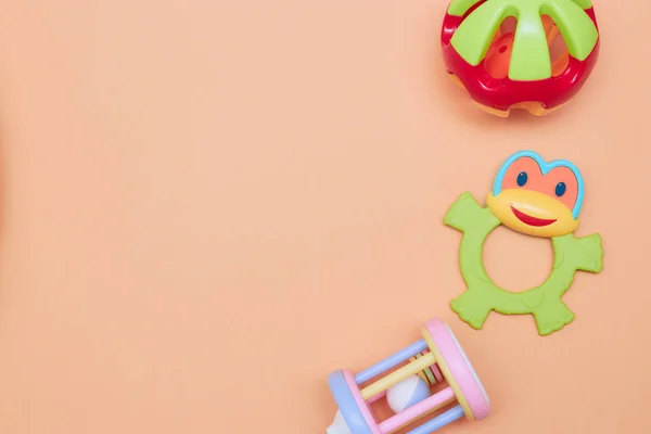 Top view of children's educational toys. Bright plastic, a plastic set of toys for children. Flatlay with space for text on a peach background. — Stock Photo, Image