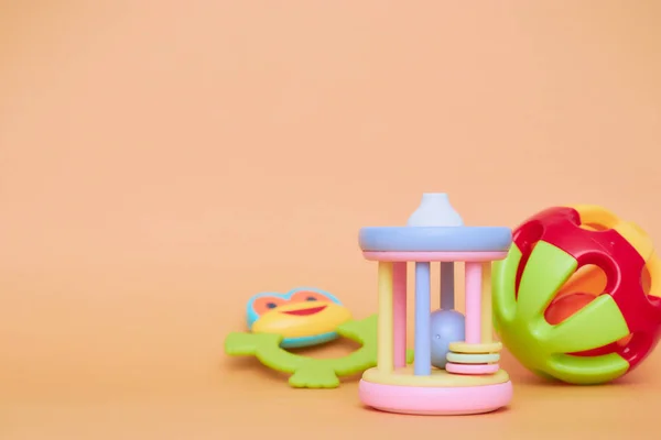 Top view of children's educational toys. Bright plastic, a plastic set of toys for children. Flatlay with space for text on a peach background. — Stock Photo, Image