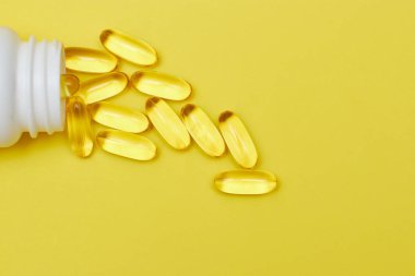 ilaç ilaç kapsülleri, hap lar ve kapsüller ve sarı bir arka plan üzerinde bir şişe. Metin için alan kopyalayın. haplarda medecine ve vitamin kavramı.