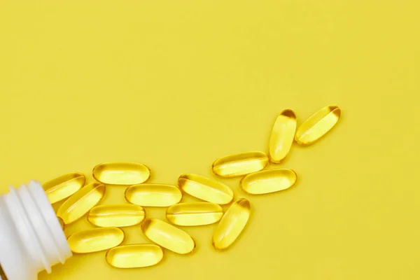 Kapseln aus der pharmazeutischen Medizin, Tabletten und Kapseln und eine Flasche auf gelbem Hintergrund von oben. Kopierraum für Text. das Konzept der Medizin und Vitamine in Pillen. — Stockfoto