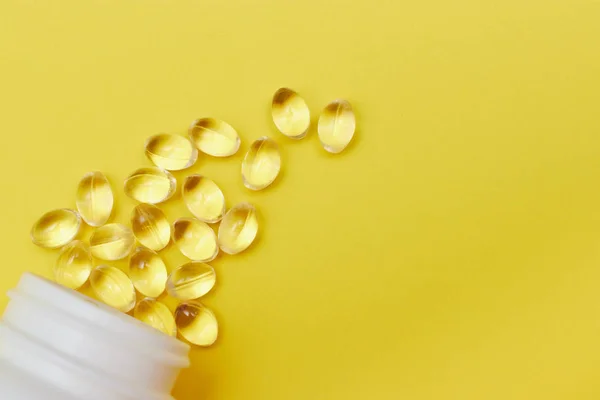 Kapseln aus der pharmazeutischen Medizin, Tabletten und Kapseln und eine Flasche auf gelbem Hintergrund von oben. Kopierraum für Text. das Konzept der Medizin und Vitamine in Pillen. — Stockfoto