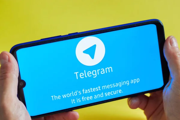 Hilversum, Holandia-23 sierpnia 2019 w rękach dziewczyny smartphone z aplikacją Telegram Messenger na żółtym tle. Koncepcja historii na portalach społecznościowych. — Zdjęcie stockowe