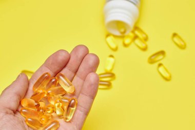 ilaç ilaç kapsülleri, hap lar ve kapsüller ve sarı bir arka plan üzerinde bir şişe. Metin için alan kopyalayın. haplarda medecine ve vitamin kavramı.