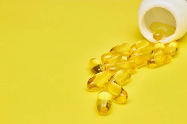 Cápsulas de medicina farmacêutica, comprimidos e cápsulas e um frasco sobre um fundo amarelo. Copiar espaço para texto. conceito de medecina e vitaminas em comprimidos . — Fotografia de Stock