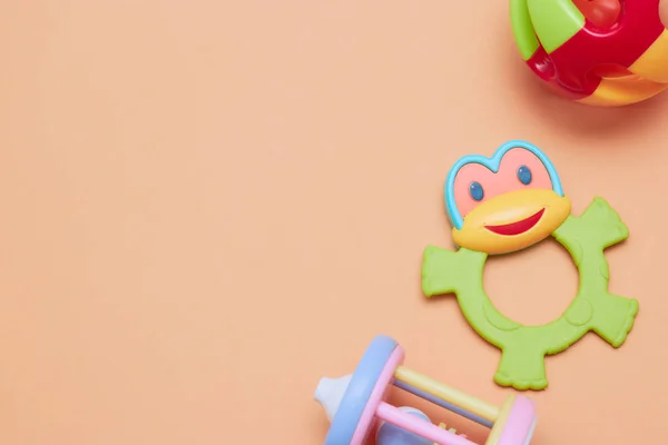Top view of children's educational toys. Bright plastic, a plastic set of toys for children. Flatlay with space for text on a peach background. — Stock Photo, Image