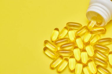 ilaç ilaç kapsülleri, hap lar ve kapsüller ve sarı bir arka plan üzerinde bir şişe. Metin için alan kopyalayın. haplarda medecine ve vitamin kavramı.