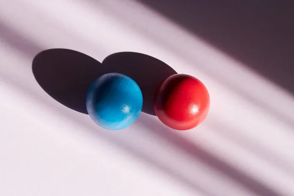 Bola roja y azul sobre un fondo claro con sombras duras. fondo abstracto para el diseño. Copia espacio geometría sombra efecto de fundición — Foto de Stock