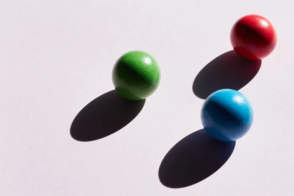 Tres bolas de colores sobre un fondo claro con sombras duras. fondo abstracto para el diseño. Copiar geometría espacial — Foto de Stock