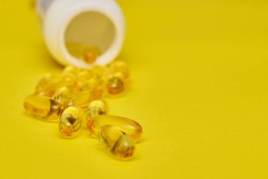 ilaç ilaç kapsülleri, hap lar ve kapsüller ve sarı bir arka plan üzerinde bir şişe. Metin için alan kopyalayın. haplarda medecine ve vitamin kavramı.